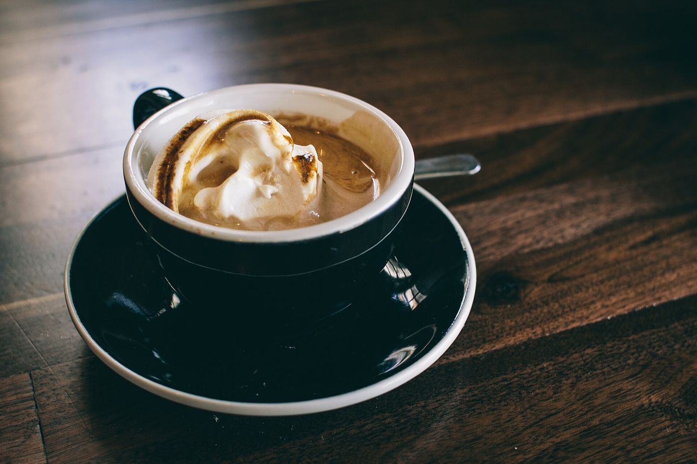 Imagem ilustrativa: cappuccino em xícara escura