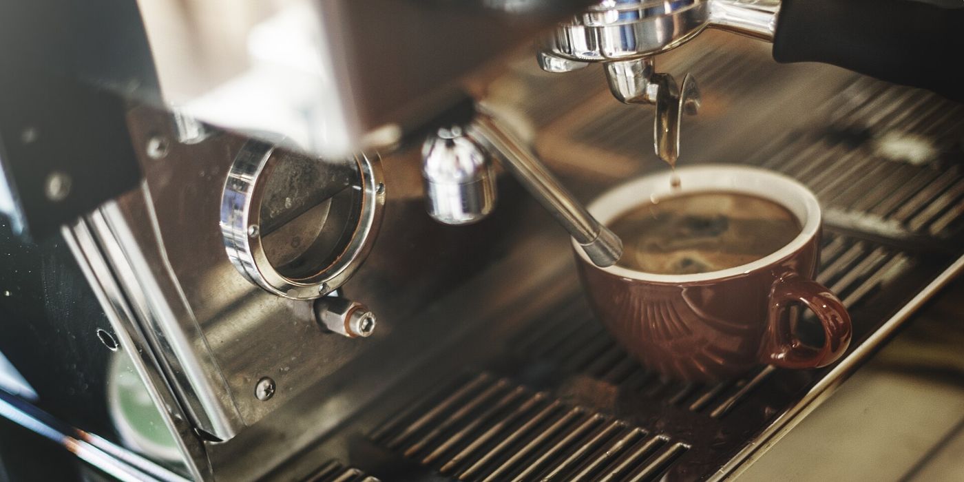 Imagem ilustrativa: máquina de espresso servindo café