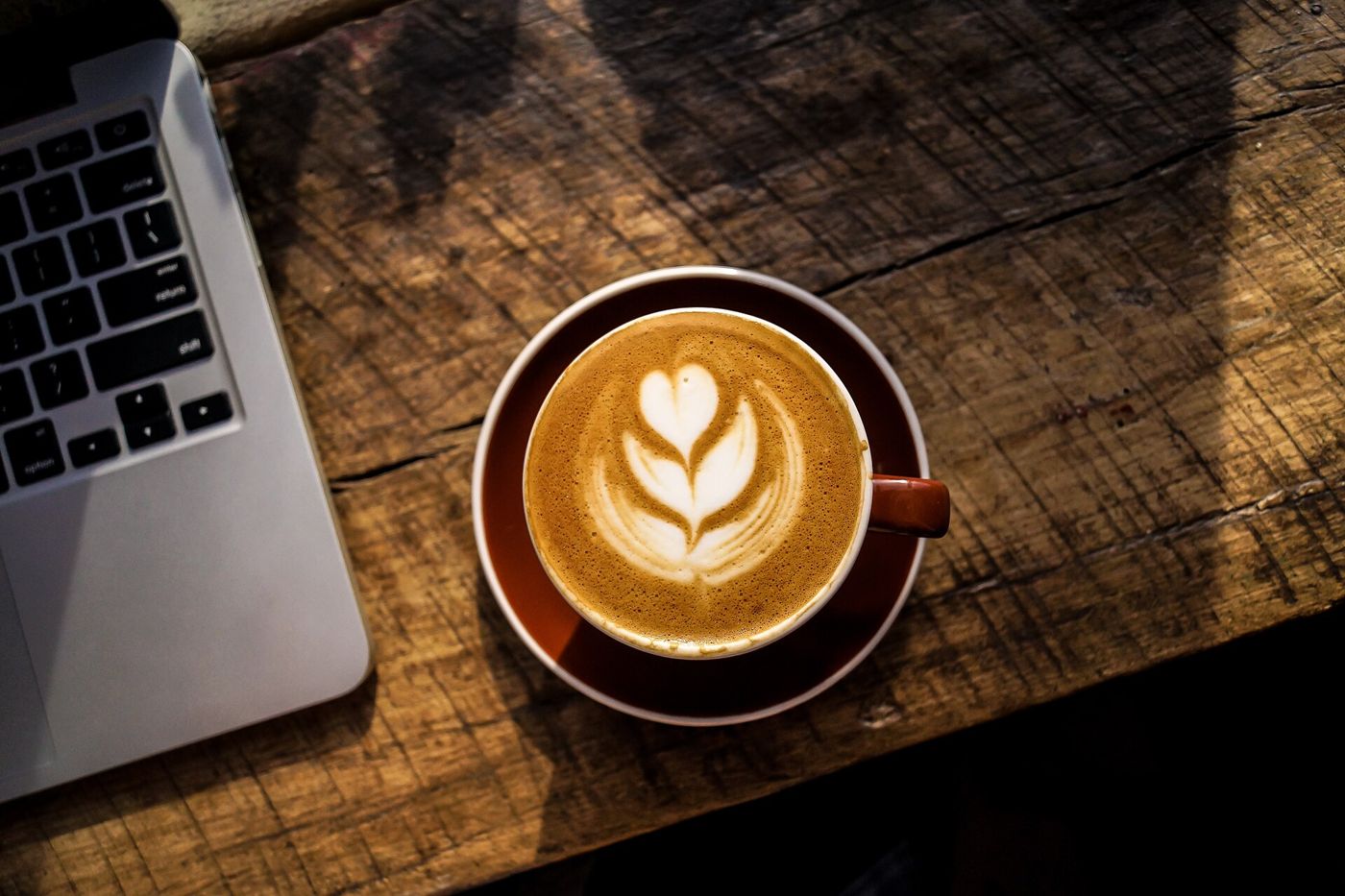 Imagem ilustrativa: latte art em xícara escura