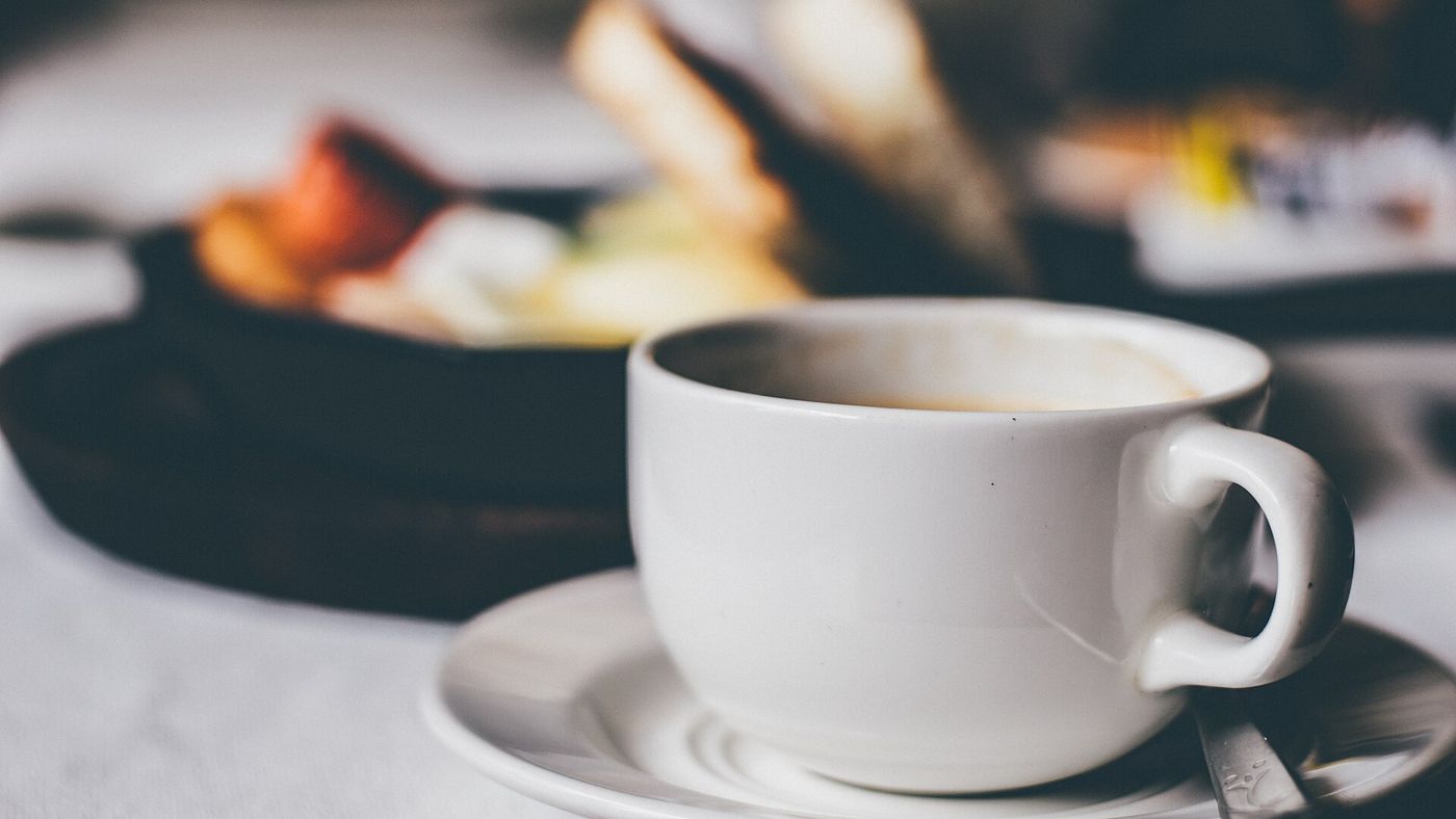 Imagem ilustrativa: xícara branca de café sobre pires