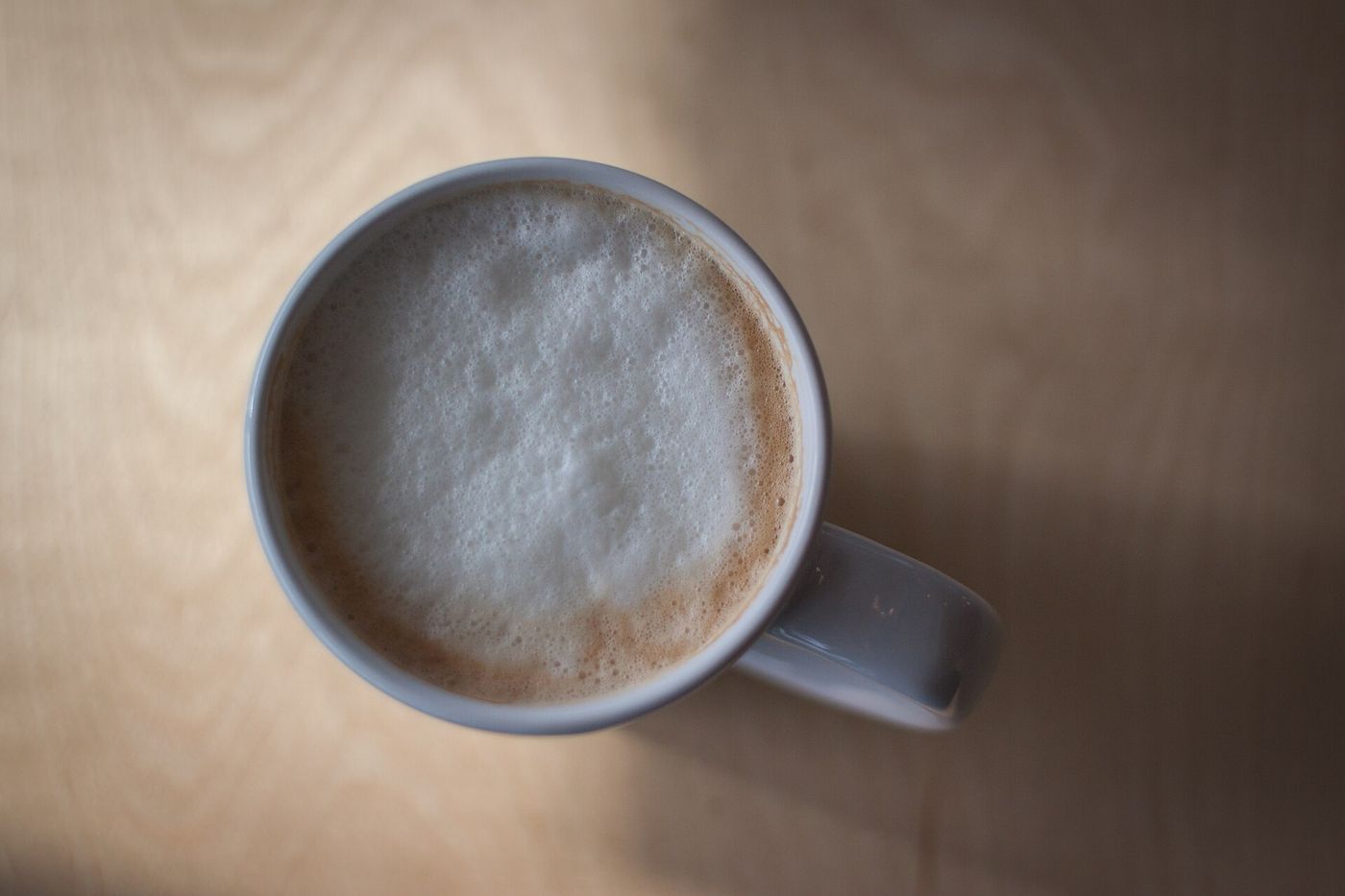 Imagem ilustrativa: café com espuma em caneca branca
