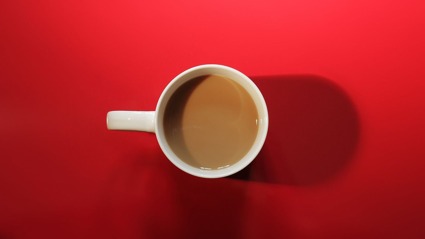 Imagem ilustrativa: xícara de café em fundo vermelho