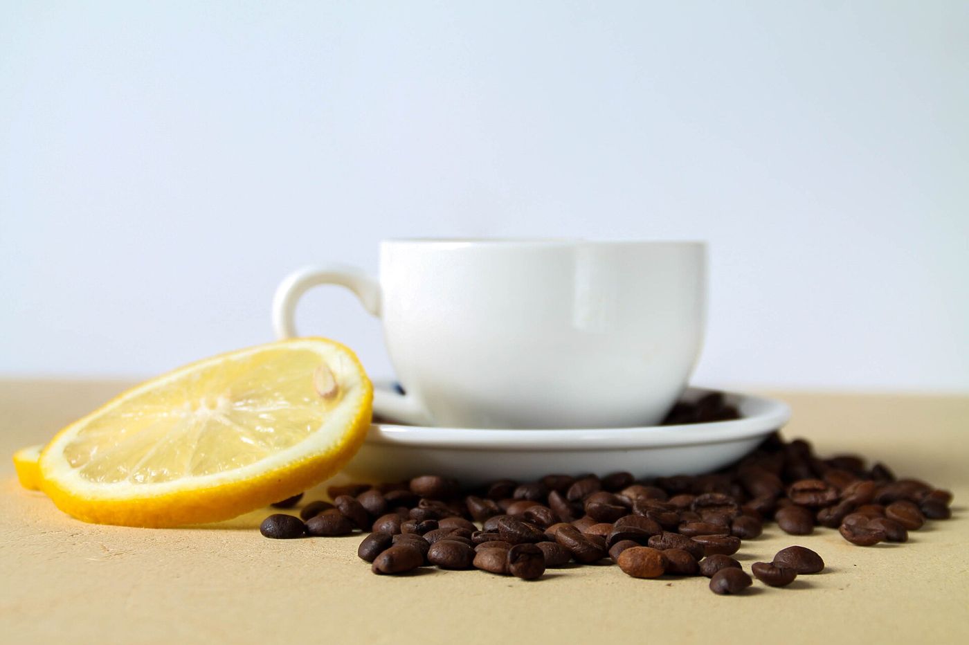 Imagem ilustrativa: xícara de café com grãos e limão